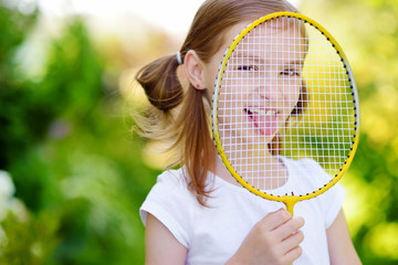 Cute little girl playing badminton outdoors