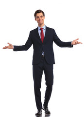 smiling young business man in suit and tie welcoming you