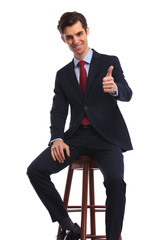 seated young business man making the ok sign