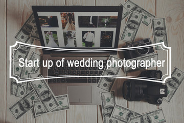 Start up for wedding photographing top view. A lot of dollars lying around laptop with wedding photos, digital and film cameras on white wooden background.