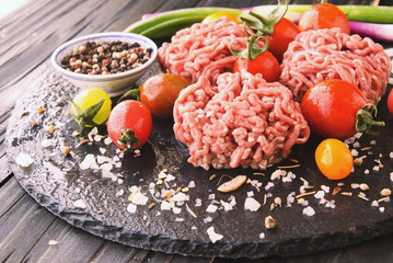raw minced meat, vegetables with salt and spices, selective focus