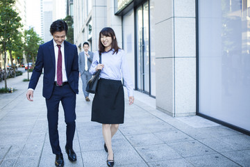 Young men and women are walking the business district together