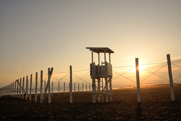 オレンジ色に染まる夕日に映える海岸の白い監視台
夕焼け空に浮かび上がる監視台のシルエットが印象的だった。