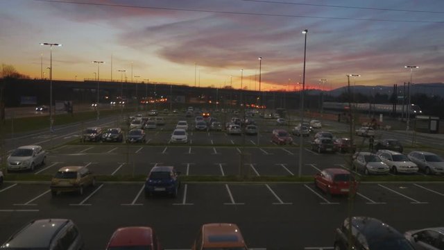Aerial dolly shot above parking area at sunset, sunrise
