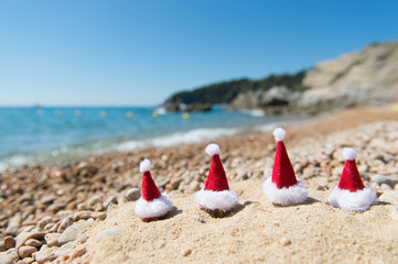 Fototapeta na wymiar Hats of Santa Claus at the beach
