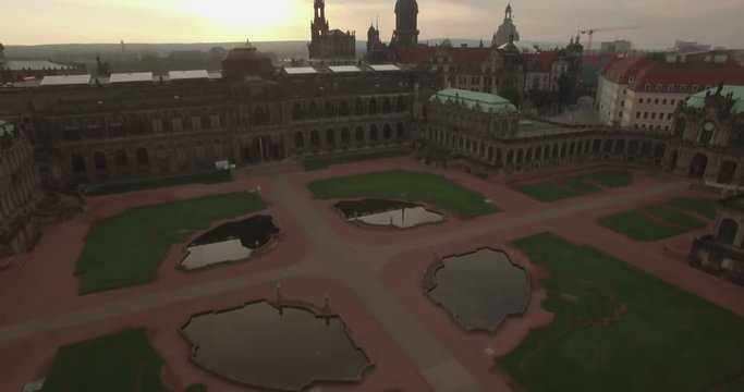 Aerial camera rises from Zwinger Palace and tilts up to reveal the Dresden skyline. Shot on a cloudy morning at dawn 