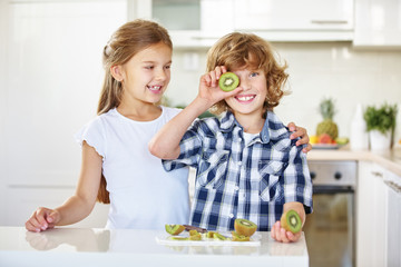 Zwei Kinder albern mit Kiwi herum