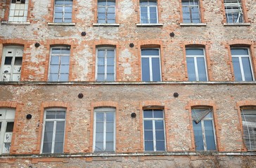industrial building with facing bricks and broken windows