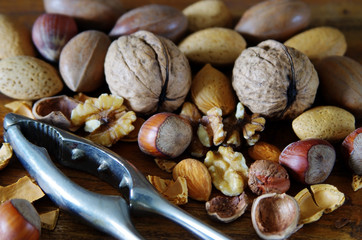 Various nuts ready to be cracked by a steel nutcracker