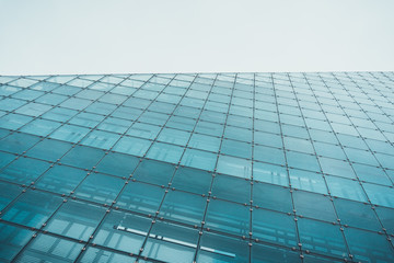Fototapeta na wymiar Tall wall of glass on skyscraper