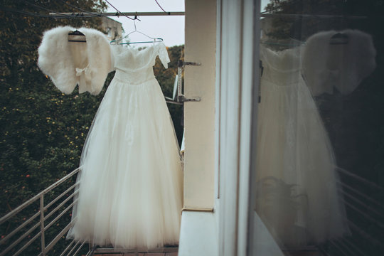 elegant stylish wedding  white dress  hanging on a balcony
