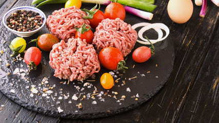 raw minced meat, vegetables with salt and spices, selective focus