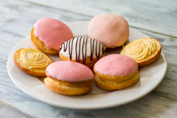 Colorful biscuits on a plate. Cookies with icing. Bush cakes with custard filling. Traditional sweets from crispy dough.