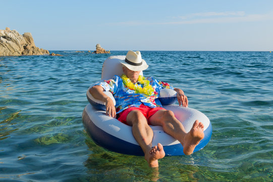 Senior man floating in sea - Powered by Adobe
