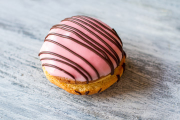 Biscuit with pink glaze. Cookie decorated by chocolate. Bush cake with sugar icing. Nutritious dessert at the cafe.