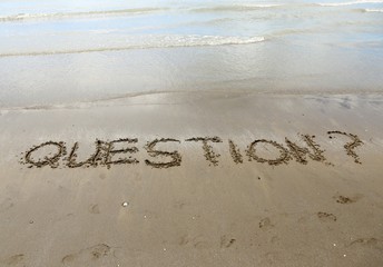 QUESTIONS written on the beach sand