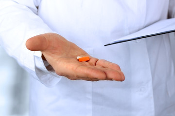 Doctor in a white  labcoat giving  pills