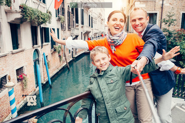 Obraz premium Happy family take a self photo on the one of bridges in Venice