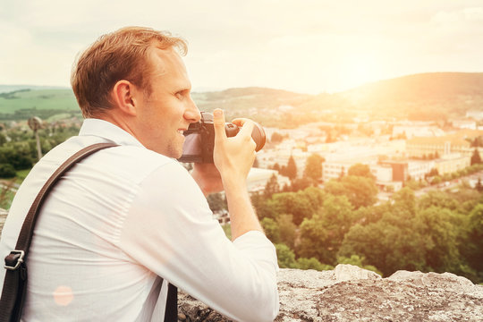 Man with professional photo camera take landscape picture