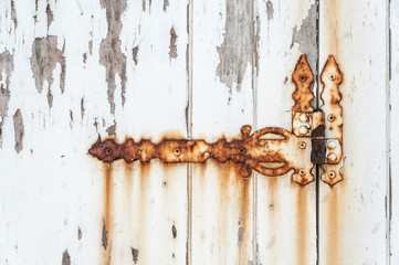 Old rusted hinge on a white door