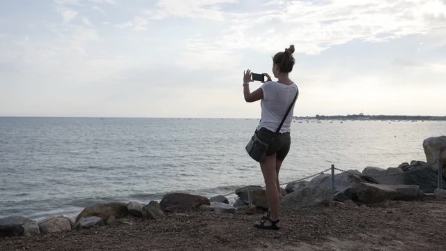 Sea scenery and female photographing before sunset with mobile slow-mo 1920X1080 HD footage - Blond woman doing photos on ocean beach slow motion 1080p FullHD video 