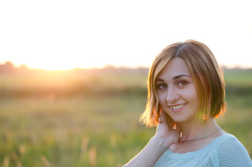 
very beautiful portrait of a red-haired girl in the park at sunset   