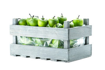 green apple in wooden crate, isolated on white background