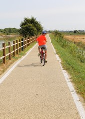 Fototapeta premium boy riding on the bike path near the lagoon of Venice