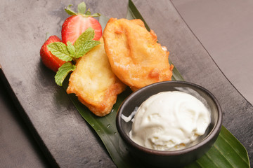 Fried banana served with ice cream and strawberry
