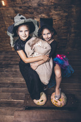 Children girls costumes witches with pumpkins and treats in the