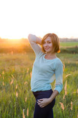 
very beautiful portrait of a red-haired girl in the park at sunset   