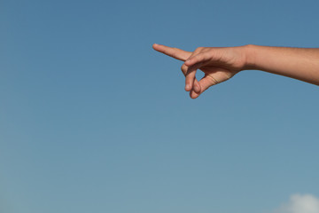 Female or children pointing finger under blue sky