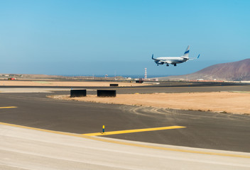 Fototapeta na wymiar Landing airplane on a airport runway
