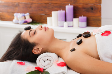 Obraz na płótnie Canvas Beautiful girl at stone massage spa in wellness center
