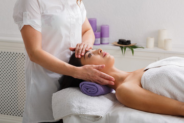 Woman beautician doctor make head massage in spa wellness center