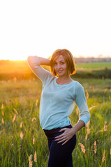 
very beautiful portrait of a red-haired girl in the park at sunset   