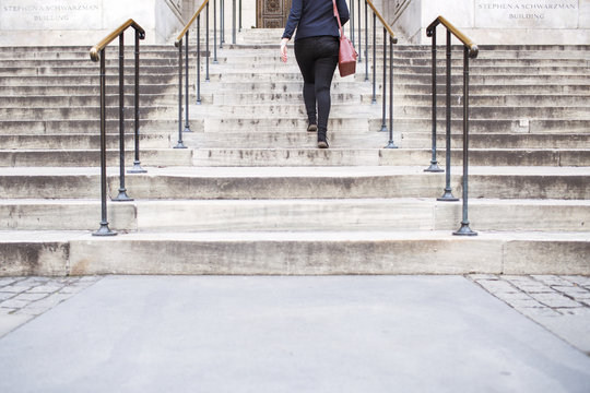 Low section of woman climbing New York Public Library's staircase