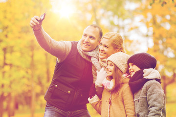 happy family with camera in autumn park