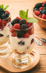 Healthy yogurt dessert with muesli, raspberries and blackberries .