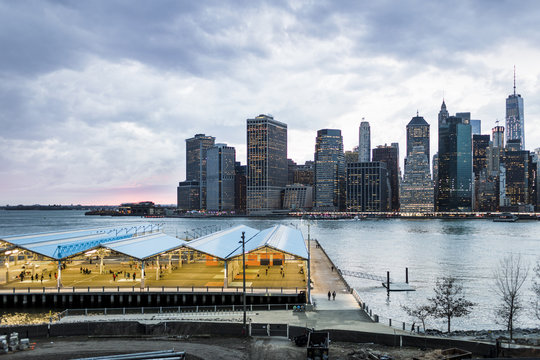 View of basketball court against East River and buildings against cloudy sky