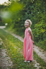 A beautiful portrait of a girl in evening dress among the garden