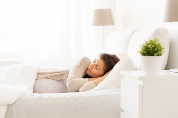 happy pregnant woman sleeping in bed at home