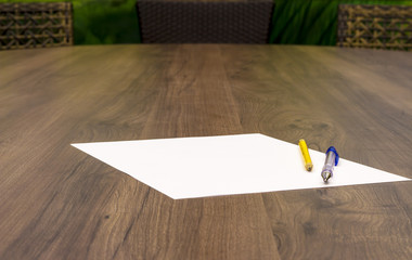 Blank paper with pen and pencil on the wooden table