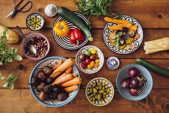 Assorted vegetables in bowls on wooden table