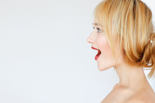 Excited happy red-haired woman profile, free space. Foxy woman smiling with opened mouth and looking right, copy space for text or advertisement. Sale, closeout, action, stock, wow concept