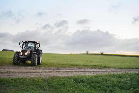 Fototapeta Tractor on grassy field against sky