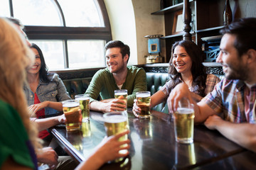 happy friends drinking beer at bar or pub