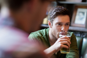 happy man with friend drinking beer at bar or pub