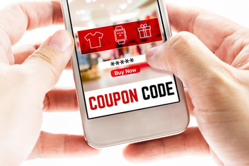 Close up Two hand holding mobile phone with coupon code word and