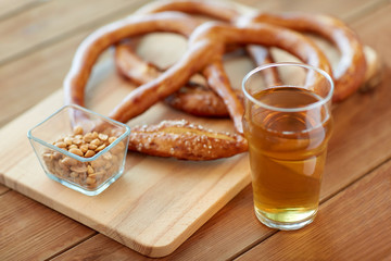 close up of beer, pretzels and peanuts on table